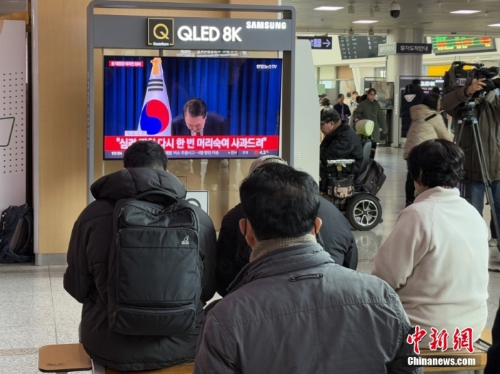 当地时间12月7日，在韩国首尔火车站，民众观看总统尹锡悦发表讲话的电视画面。韩国总统尹锡悦当日通过电视直播发表对国民谈话，就短暂紧急戒严风波向国民道歉。中新社记者 刘旭 摄