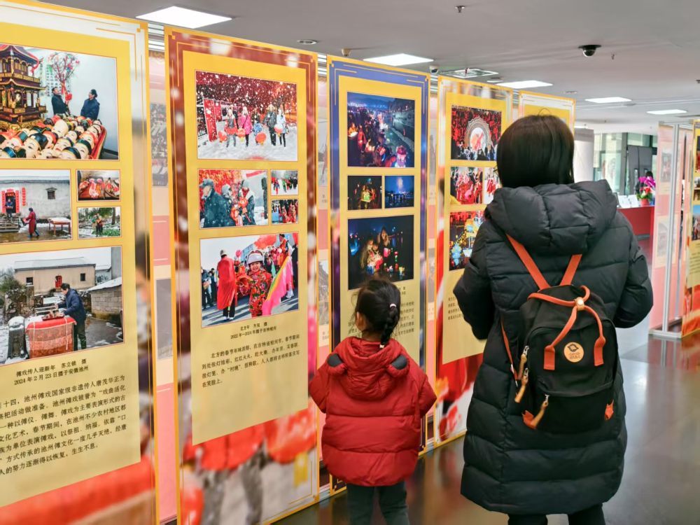 2025年1月22日，观众在国家图书馆参观“金蛇献瑞——乙巳蛇年春节非遗暨民俗摄影联展”。新华社记者 李明辉 摄