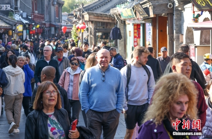 资料图：北京什刹海地区，外国游客在胡同内参观游览。中新社记者 贾天勇 摄