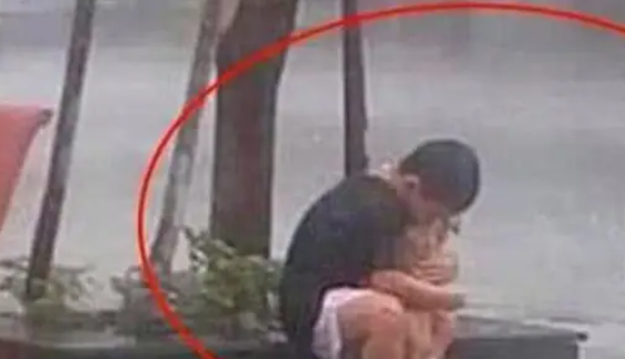 男孩雨中抱着狗狗不放，拒绝进屋避雨，直到一名男子出现才明白 