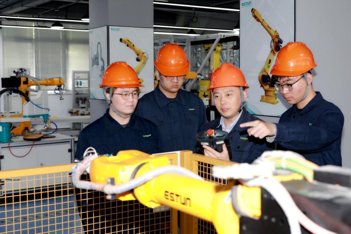 教师正在指导企业员工进行机器人编程与运维。学校供图