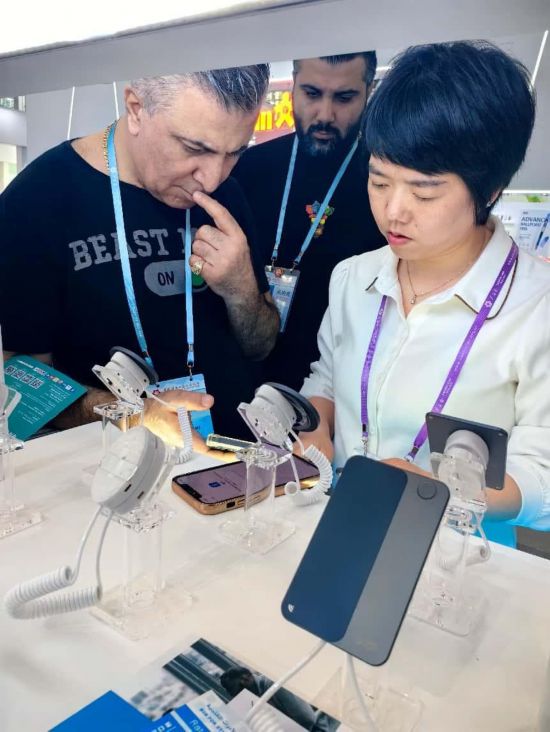 展台工作人员向外商展示“AI TOP翻译终端”。图片来源：受访者提供
