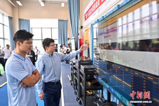 图为苏炳添在训练基地内了解数字化跑道分析系统。中新社记者 陈骥旻 摄